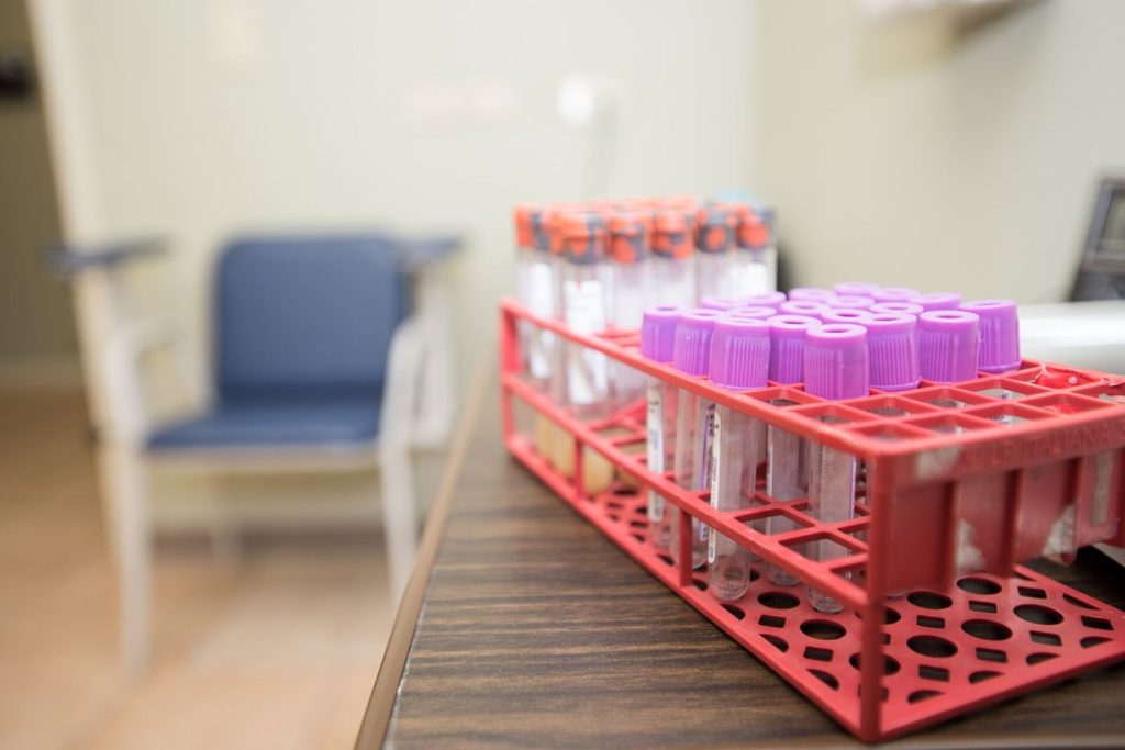 Patients sit in a bright community clinic waiting room before their appointments.